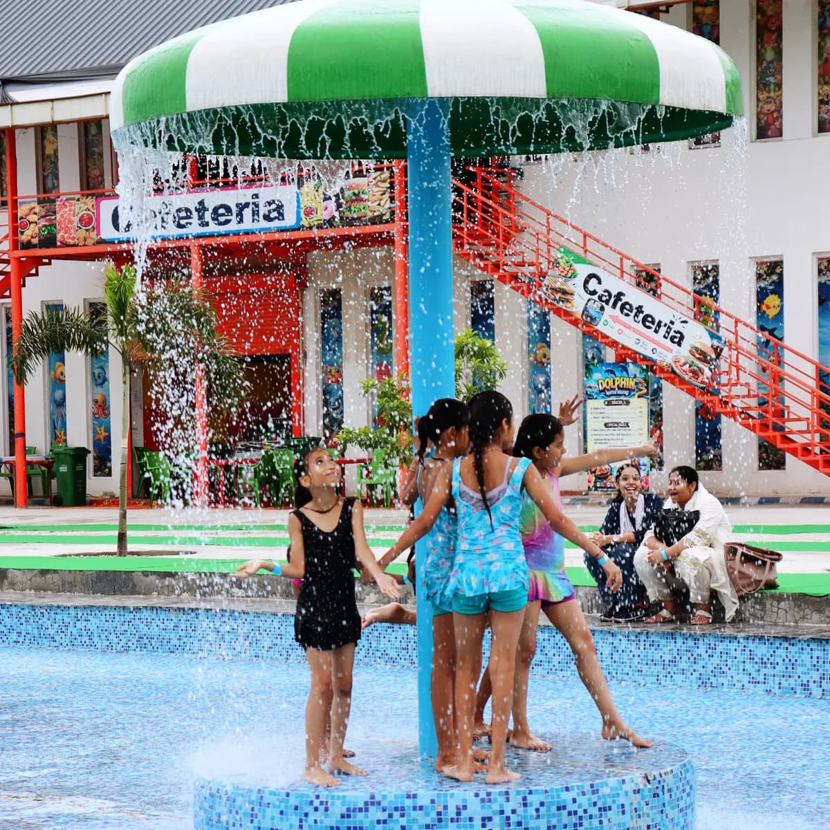 Children playing under the mushroom shower beside the cafeteria